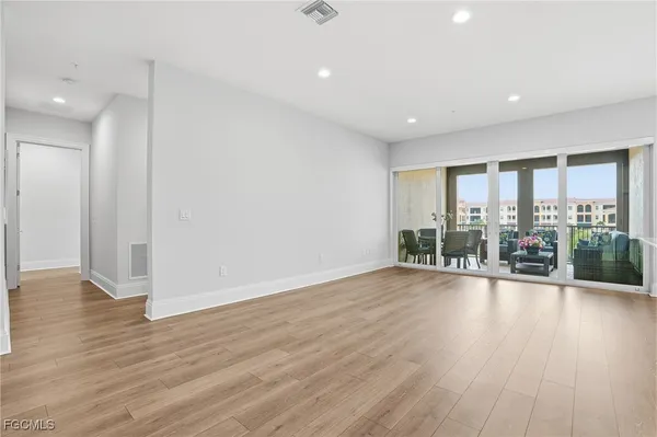 a view of room with wooden floor and floor to ceiling window
