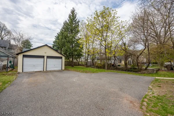 a view of empty house with tree and wooden fence
