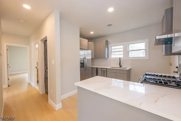a kitchen with a refrigerator and a stove top oven