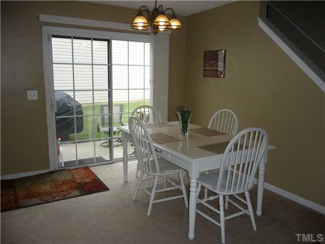 1709 Beacon Bluff Street Raleigh, NC 27604 - Photo 8 of 20 a view of a dining room with furniture a chandelier and wooden floor