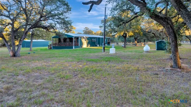 a view of a house with yard and tree s