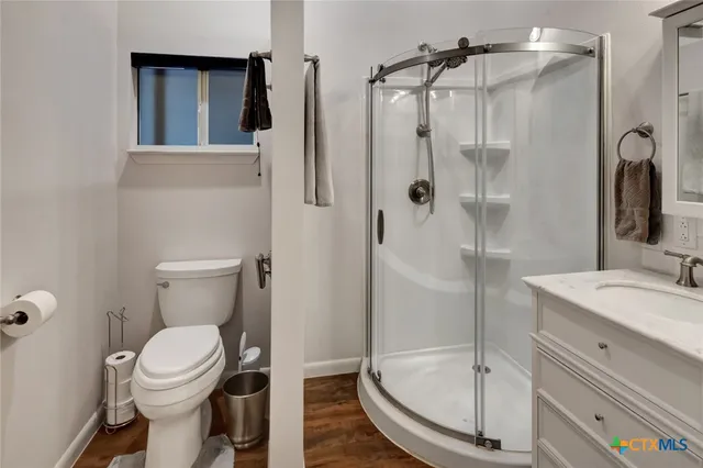 a living room with furniture kitchen view and a wooden floor