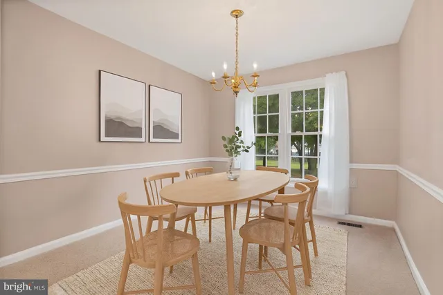 a dining room with furniture a chandelier and wooden floor