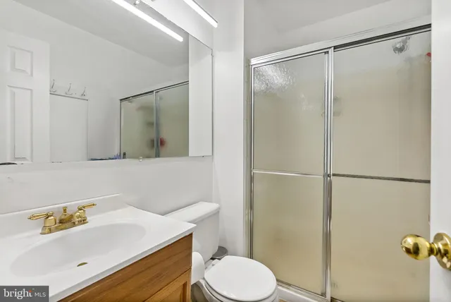 a bathroom with a sink vanity mirror and toilet