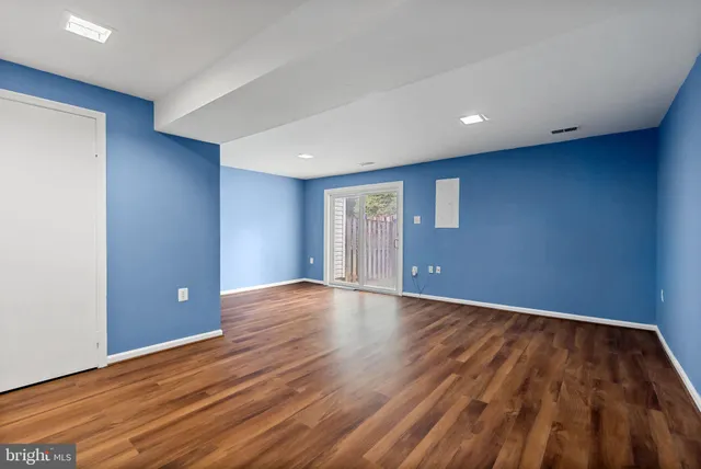 a view of empty room with wooden floor