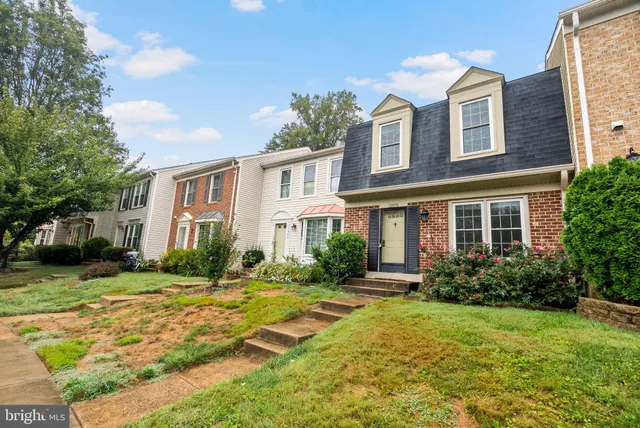 a front view of a house with garden and trees