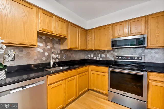 a kitchen with granite countertop cabinets stainless steel appliances and a sink