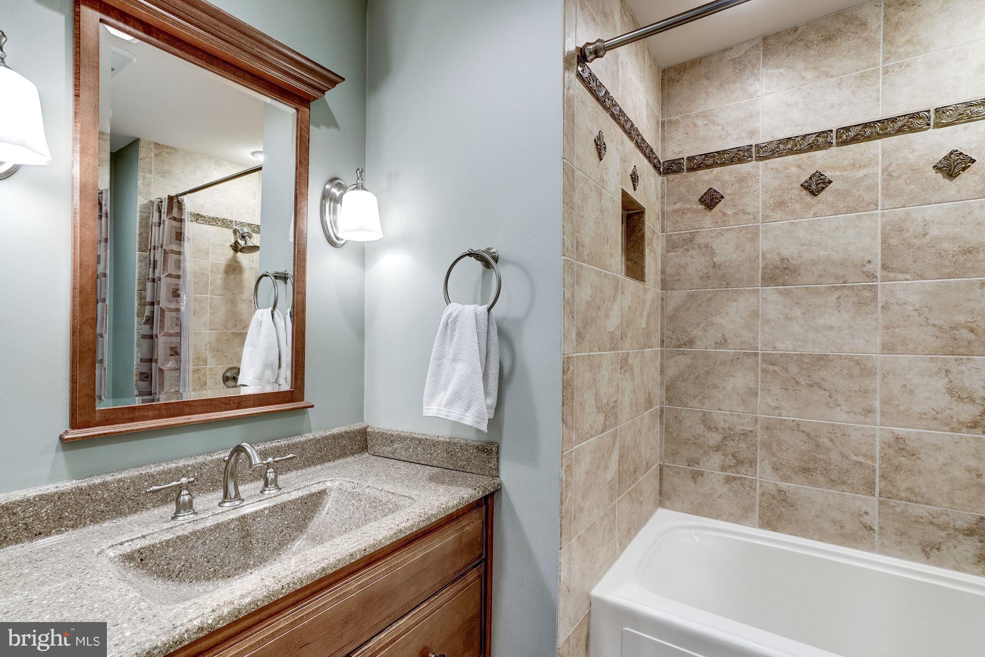 2035 Golf Course Drive Reston, VA 20191 - Photo 18 of 28 a bathroom with a granite countertop sink mirror and a bathtub