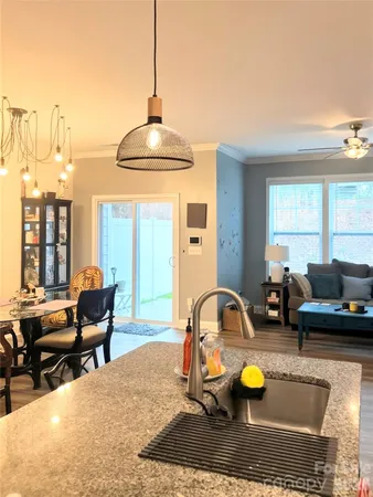 a living room with furniture two window and a flat screen tv