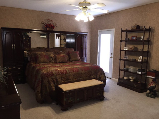 4433 Johnstonville Road Forsyth, GA 31029 - Photo 9 of 37 a bedroom with a bed a wall painting and a lamp
