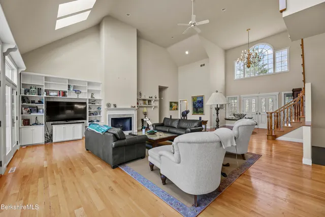 a living room with furniture a floor to ceiling window and a flat screen tv