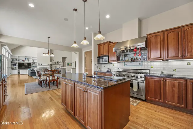 a bathroom with a tub a sink a large mirror and a bathtub next to a window