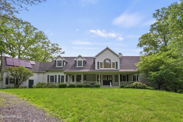 a front view of a house with a garden and trees