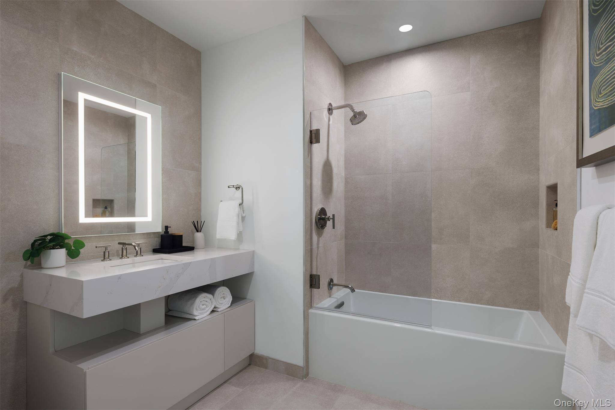 140 Boardwalk, Unit L3 B Long Beach, NY 11561 - Photo 9 of 31 a bathroom with a bathtub a mirror a sink and a shower