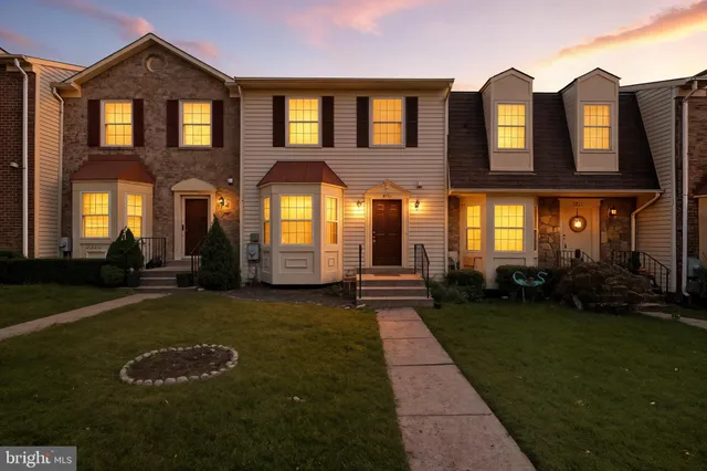 a view of a brick house with a yard in front of it