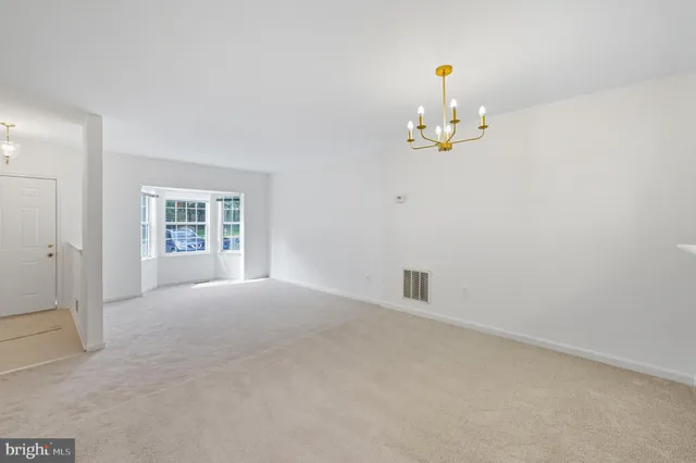 an empty room with windows and ceiling fan