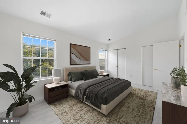 a bedroom with a large bed and a potted plant