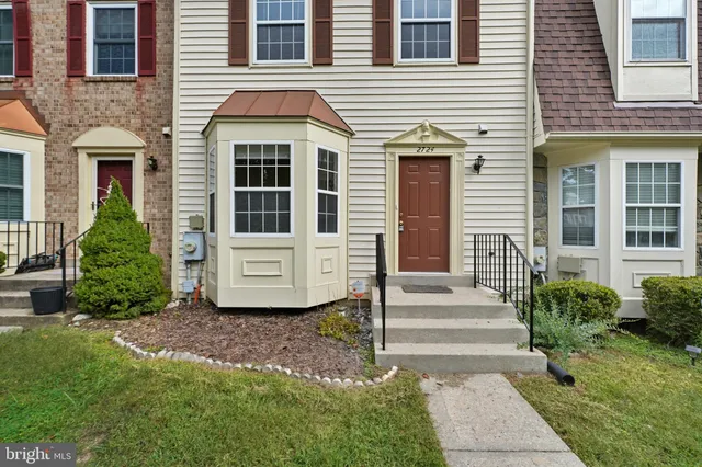 a view of a house with potted plants and a yard
