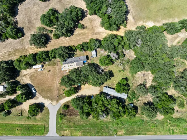 an aerial view of a house with a yard and outdoor seating