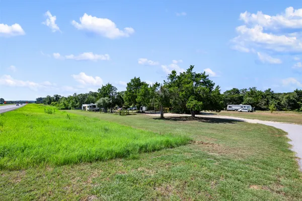a view of a green field with wooden fence