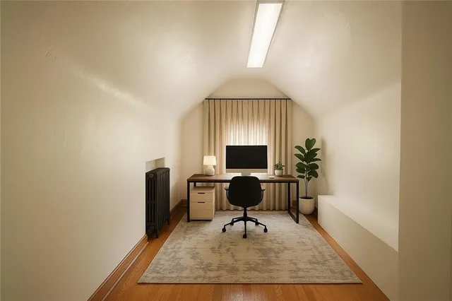 a view of a workspace with furniture and a window
