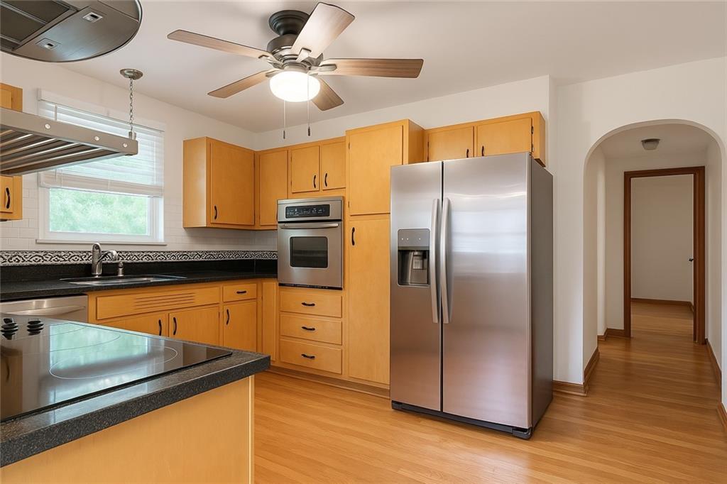 902 Delafield Road Pittsburgh, PA 15215 - Photo 8 of 23 a kitchen with stainless steel appliances granite countertop a refrigerator a stove and a sink with wooden floor