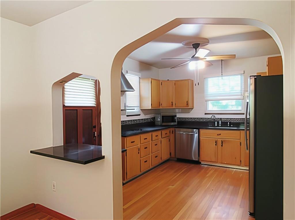 902 Delafield Road Pittsburgh, PA 15215 - Photo 9 of 23 a kitchen with stainless steel appliances granite countertop a refrigerator a sink dishwasher a stove and white countertops with wooden floor