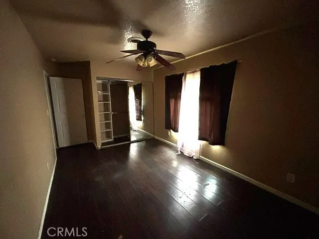 a view of a livingroom with wooden floor and a ceiling fan