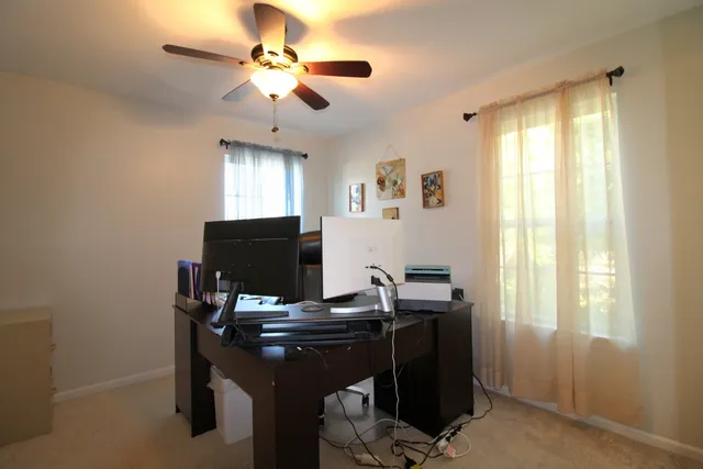 a view of a workspace with furniture and a window