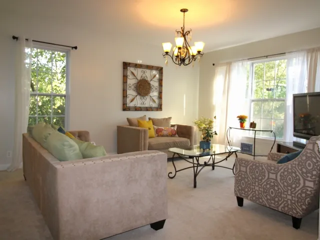 a living room with furniture and a chandelier