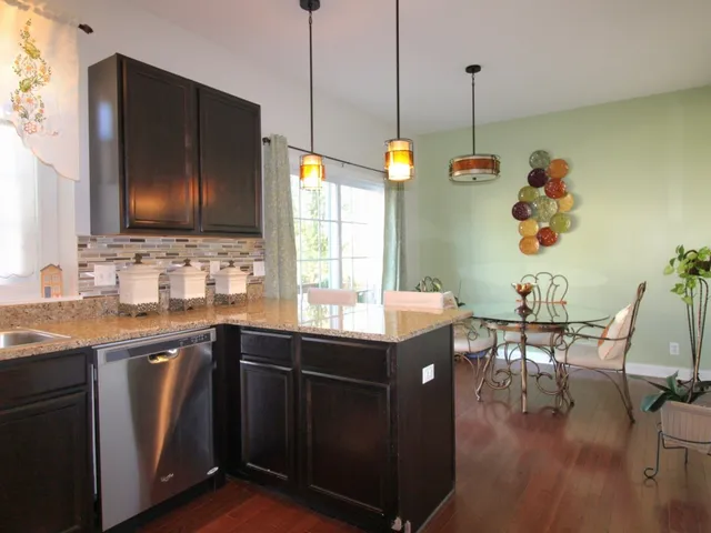 a kitchen with stainless steel appliances granite countertop a sink a stove and a wooden floors