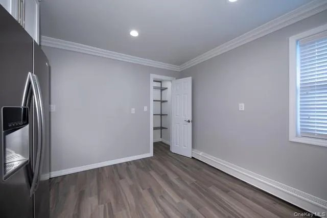 a view of empty room with wooden floor and window