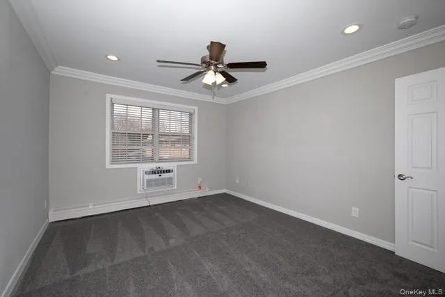an empty room with windows and ceiling fan