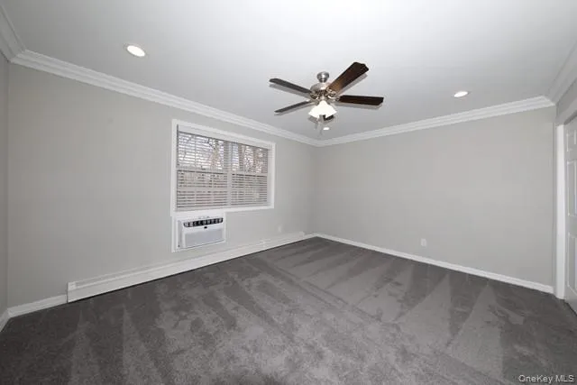 an empty room with windows and ceiling fan