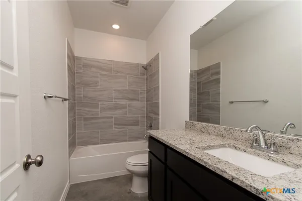 a bathroom with a granite countertop sink toilet and shower