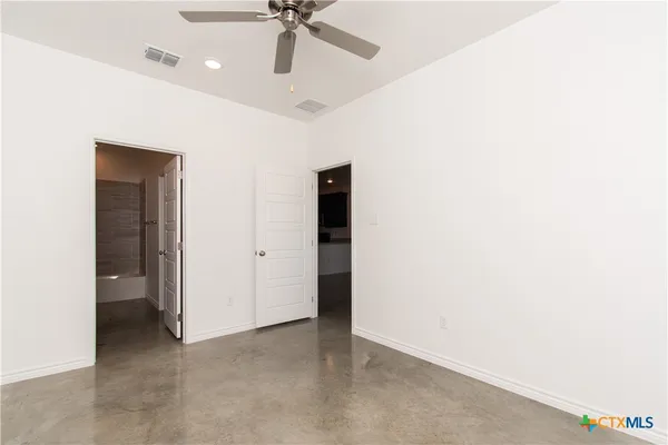 an empty room with a ceiling fan and a window
