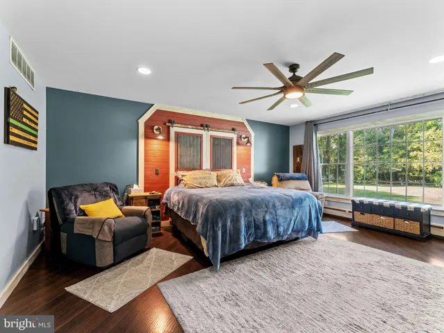 a bedroom with a bed and a large window