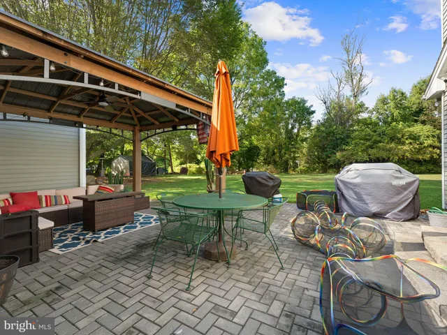 a view of a patio with a table chairs and a fire pit