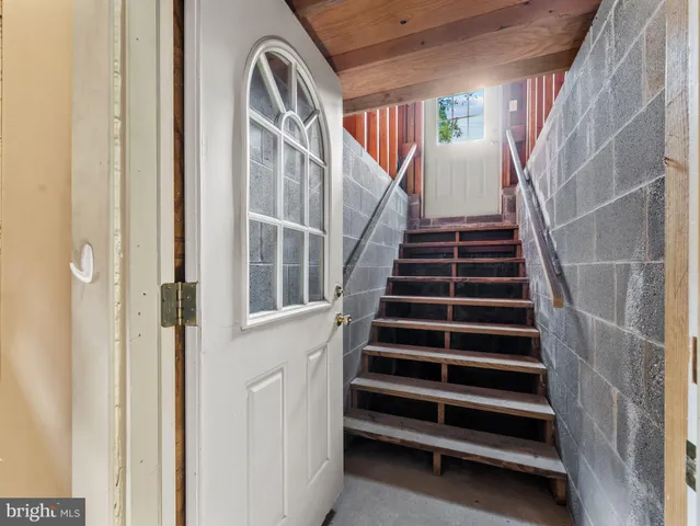 a view of staircase with railing and white walls