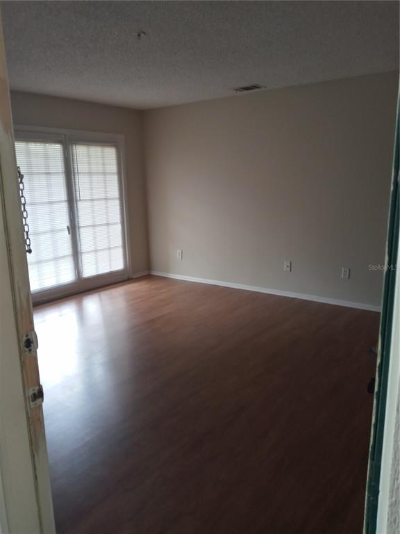 216 Afton Square, Unit 208 Altamonte Springs, FL 32714 - Photo 12 of 19 an empty room with wooden floor and windows
