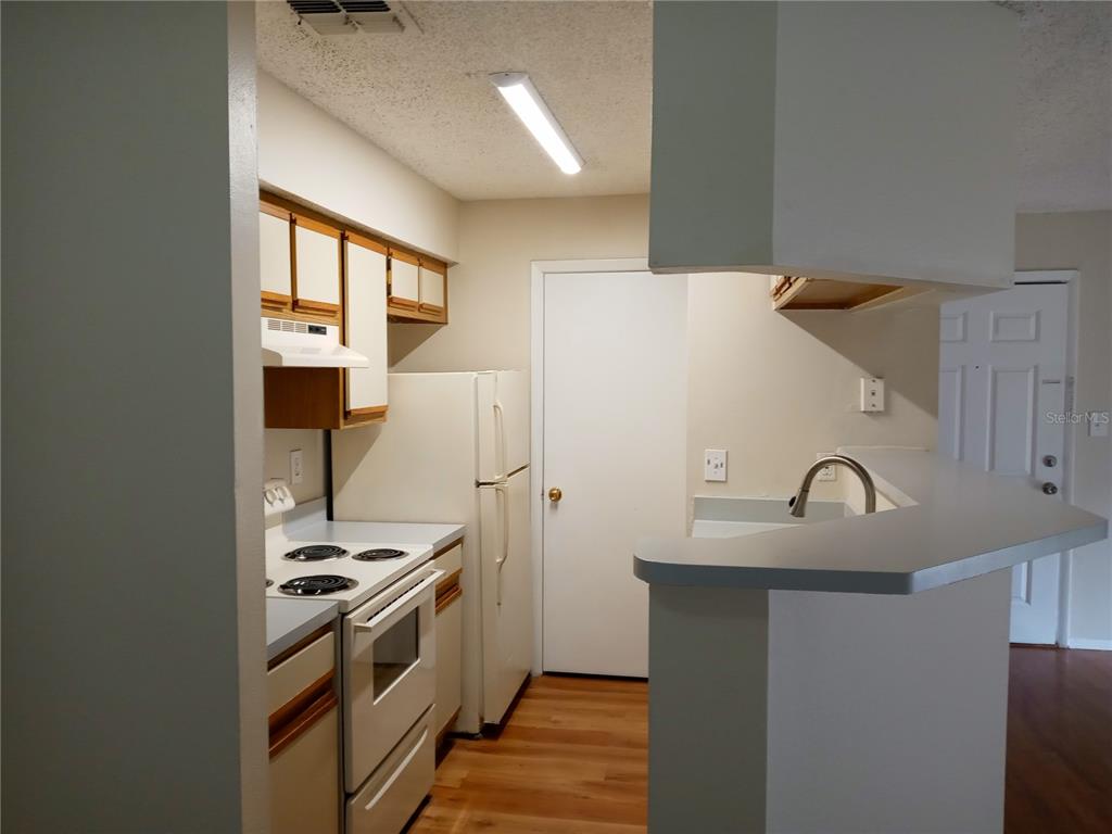 216 Afton Square, Unit 208 Altamonte Springs, FL 32714 - Photo 5 of 19 a kitchen with granite countertop a refrigerator stove and sink