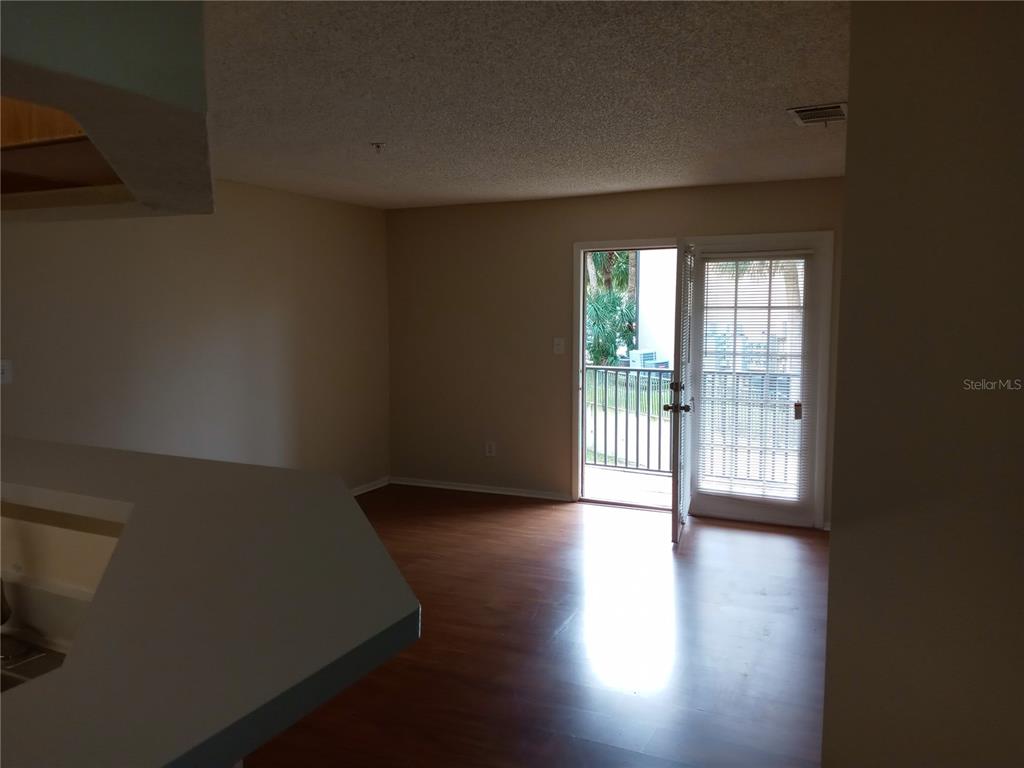 216 Afton Square, Unit 208 Altamonte Springs, FL 32714 - Photo 8 of 19 a view of an empty room with wooden floor and a window