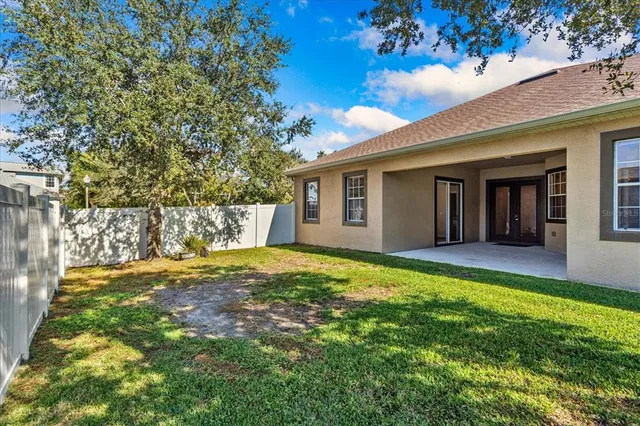 a view of a house with backyard and tree