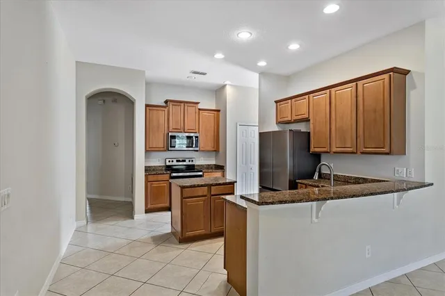 a kitchen with stainless steel appliances granite countertop a refrigerator stove and sink