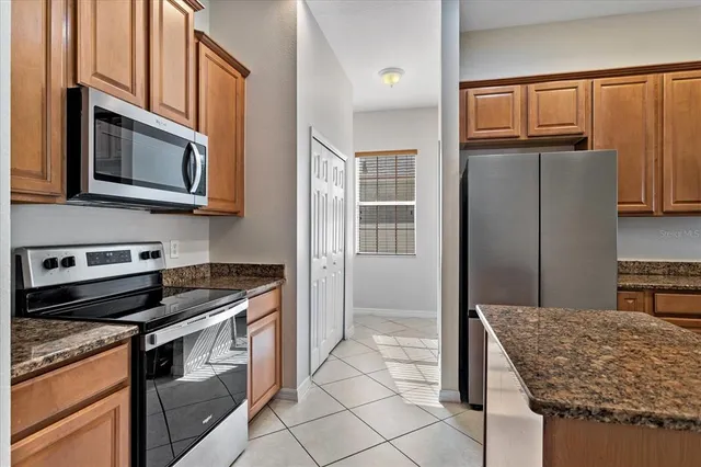 a kitchen with stainless steel appliances granite countertop a stove microwave and refrigerator