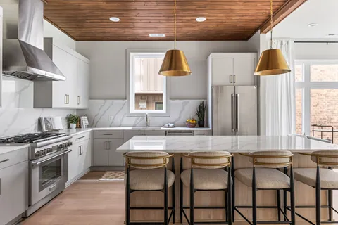 a kitchen with a table chairs sink and cabinets