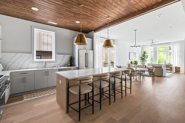 a kitchen with lots of white furniture a dining table and chairs