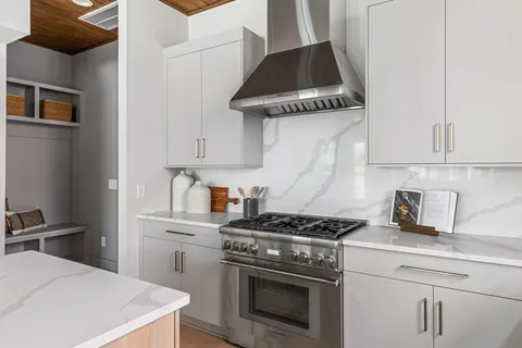 a kitchen with stainless steel appliances a stove a sink and cabinets