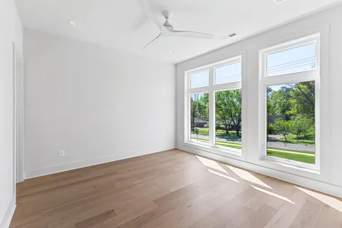 an empty room with wooden floor and white walls