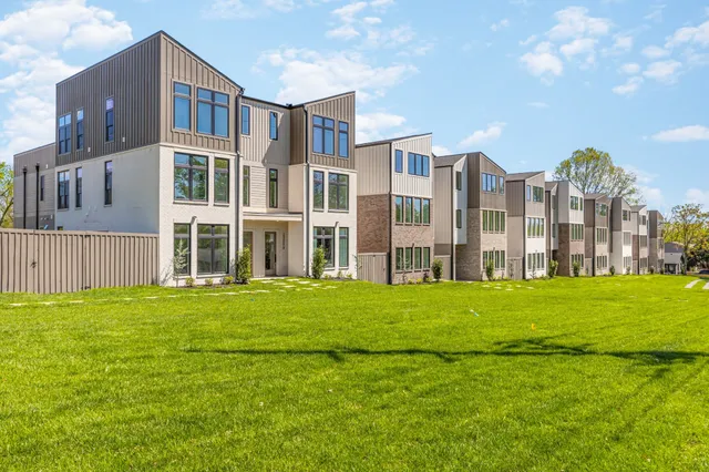 a front view of a residential apartment building with a yard